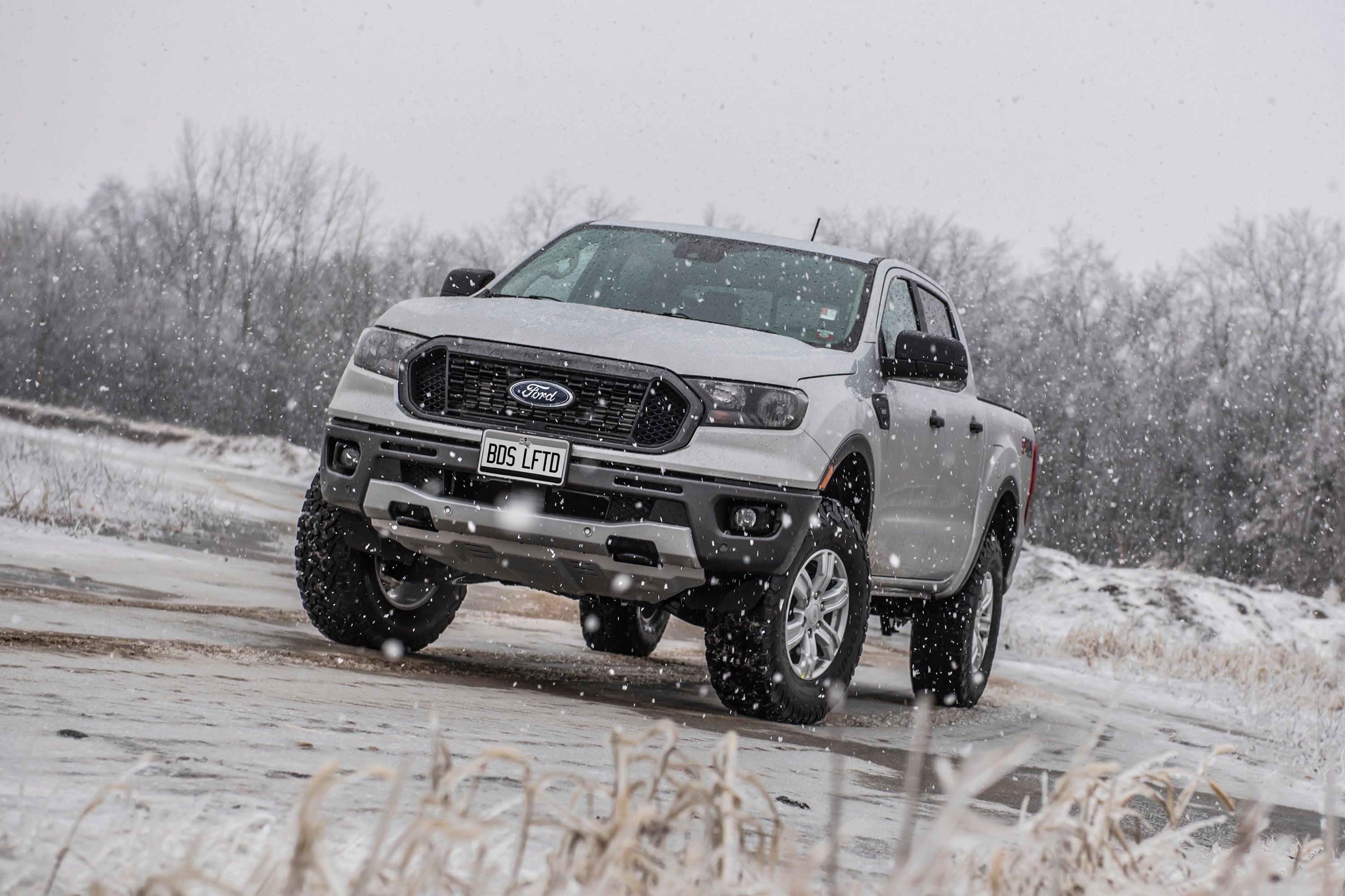 Ford Ranger with a 2-inch leveling kit, showcasing enhanced stance and off-road capability in snowy conditions.