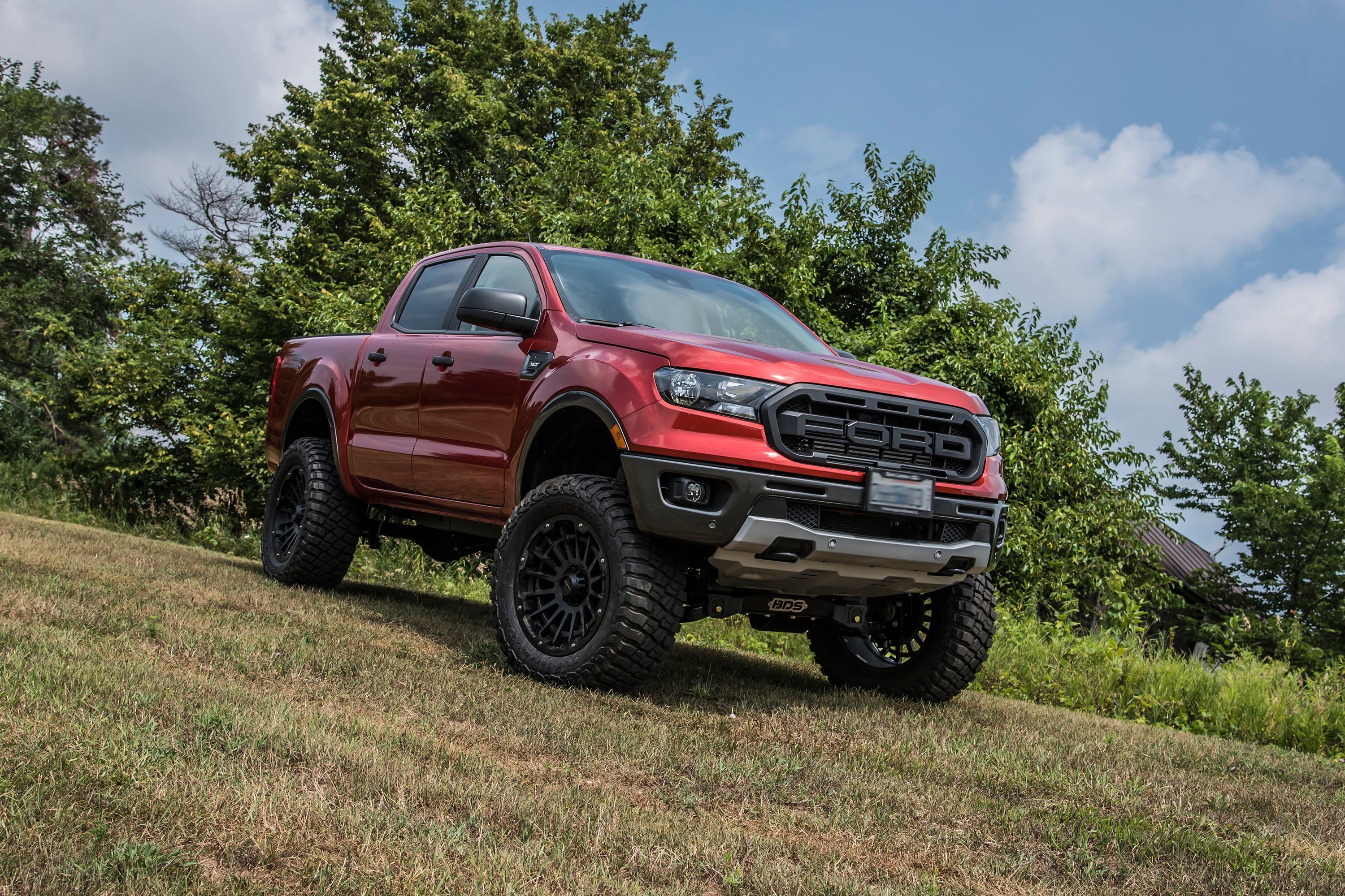 6-inch lift kit with FOX 2.5 coil-over installed on a lifted red Ford Ranger 4WD, showcasing offroad capability.