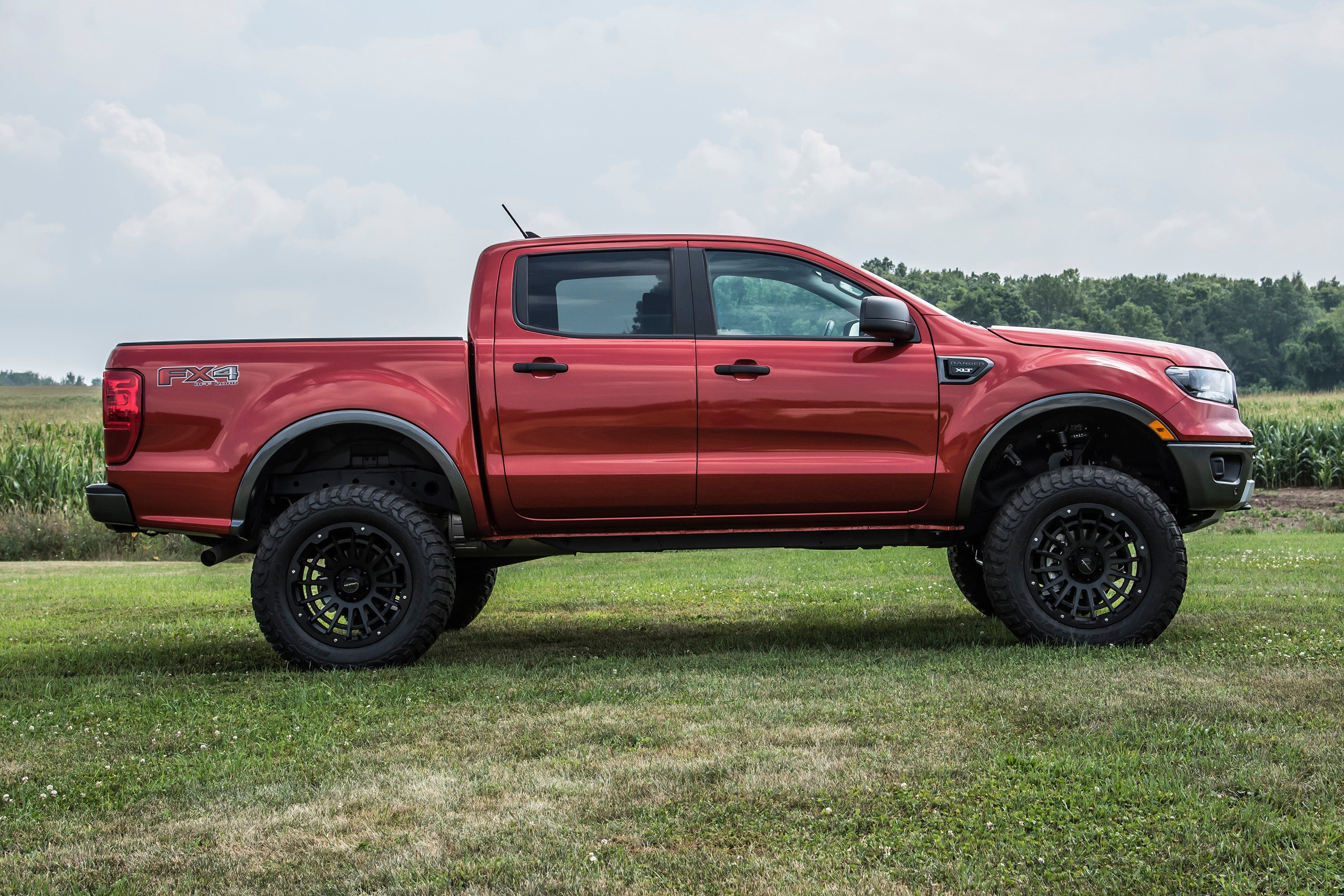 6 inch lift kit for 2019-2023 Ford Ranger 4WD showcased on a lifted red truck in a grassy field.