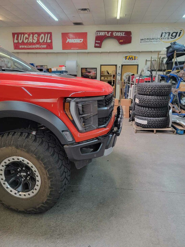 2024 Raptor Front Light Mount Kit on a red truck, showcasing a modular bumper designed for versatile light installation.