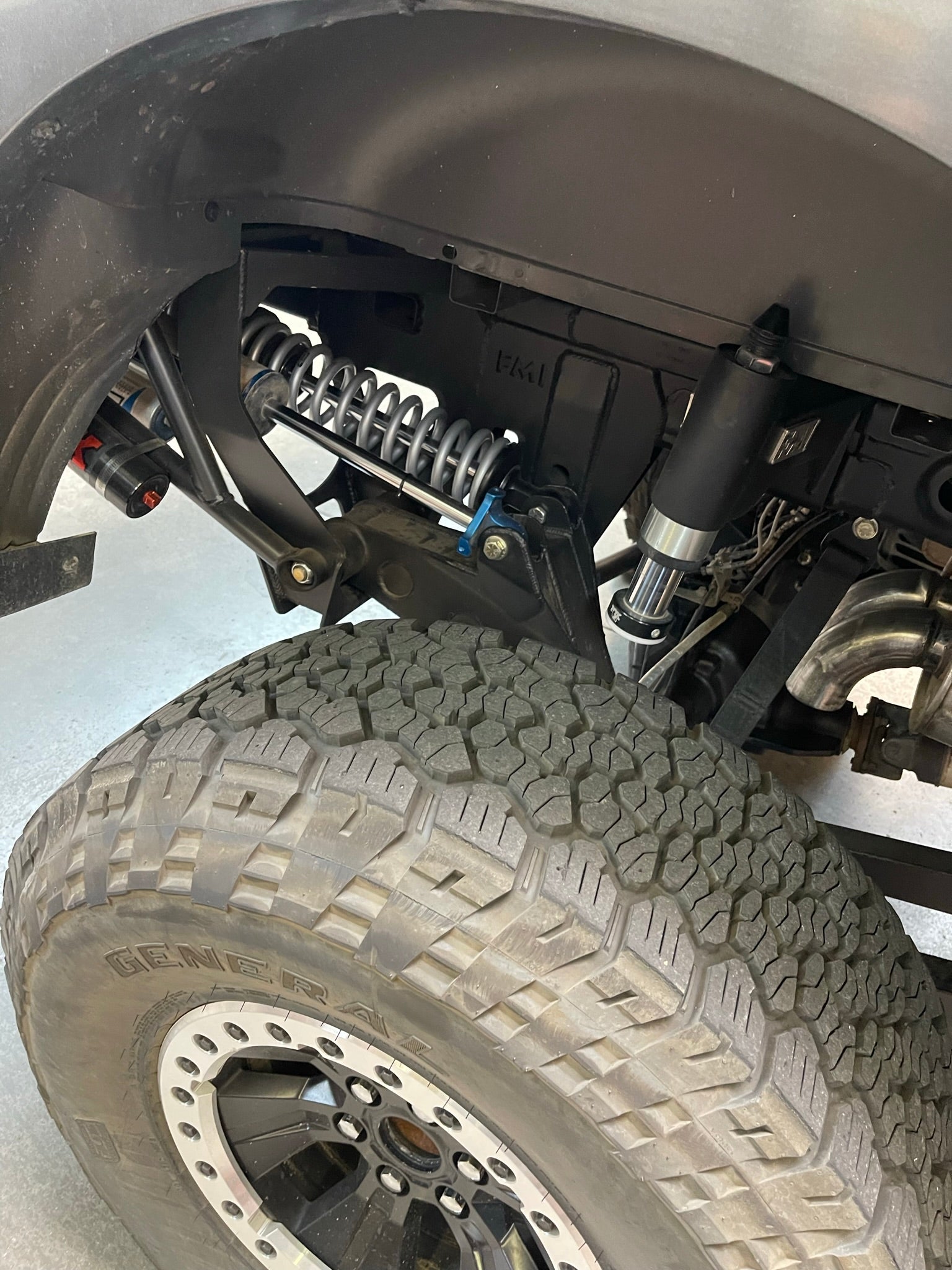 2021-2024 Raptor Long Travel Rear Suspension Kit showcasing 19 inches of travel, installed on a truck's rear axle.