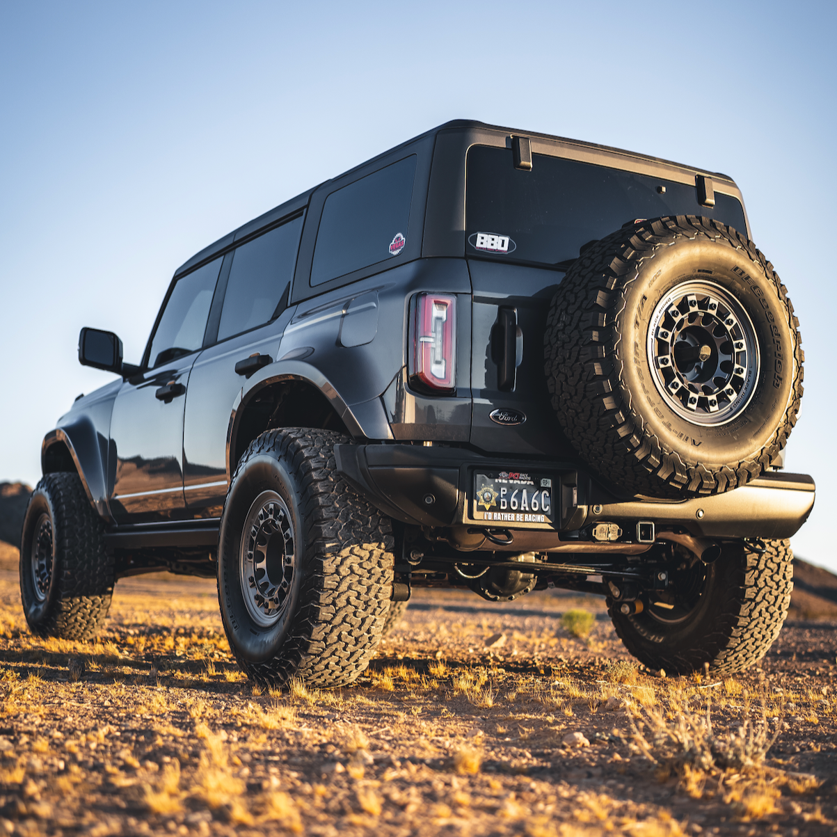 2021-2025 Ford Bronco 4-Door Rear Quarter Kit installed on a black Bronco in a desert setting, showcasing rugged off-road design.