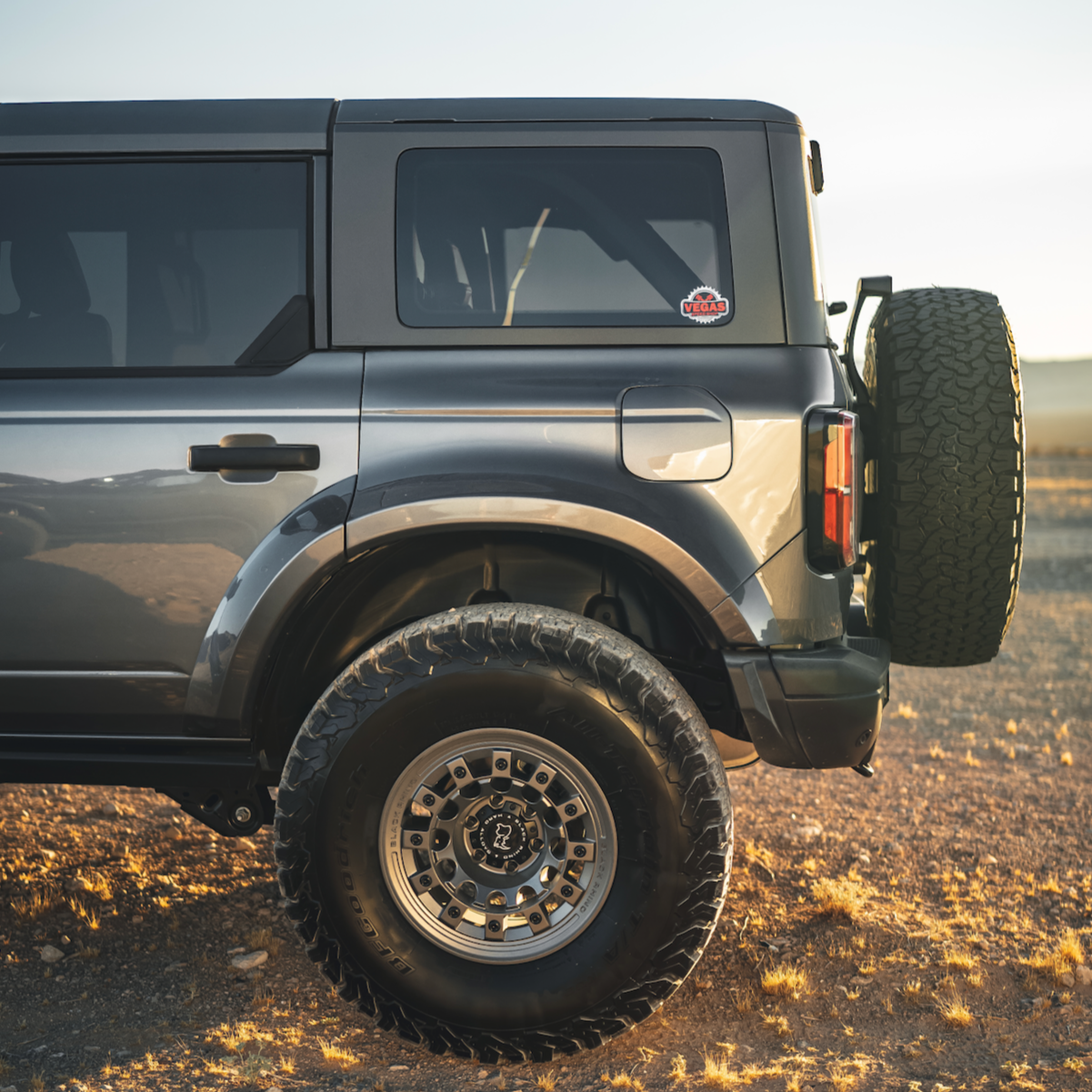 2021-2025 Ford Bronco 4-Door Rear Quarter Kit showcasing a sleek design and rugged offroad tires in a desert setting.