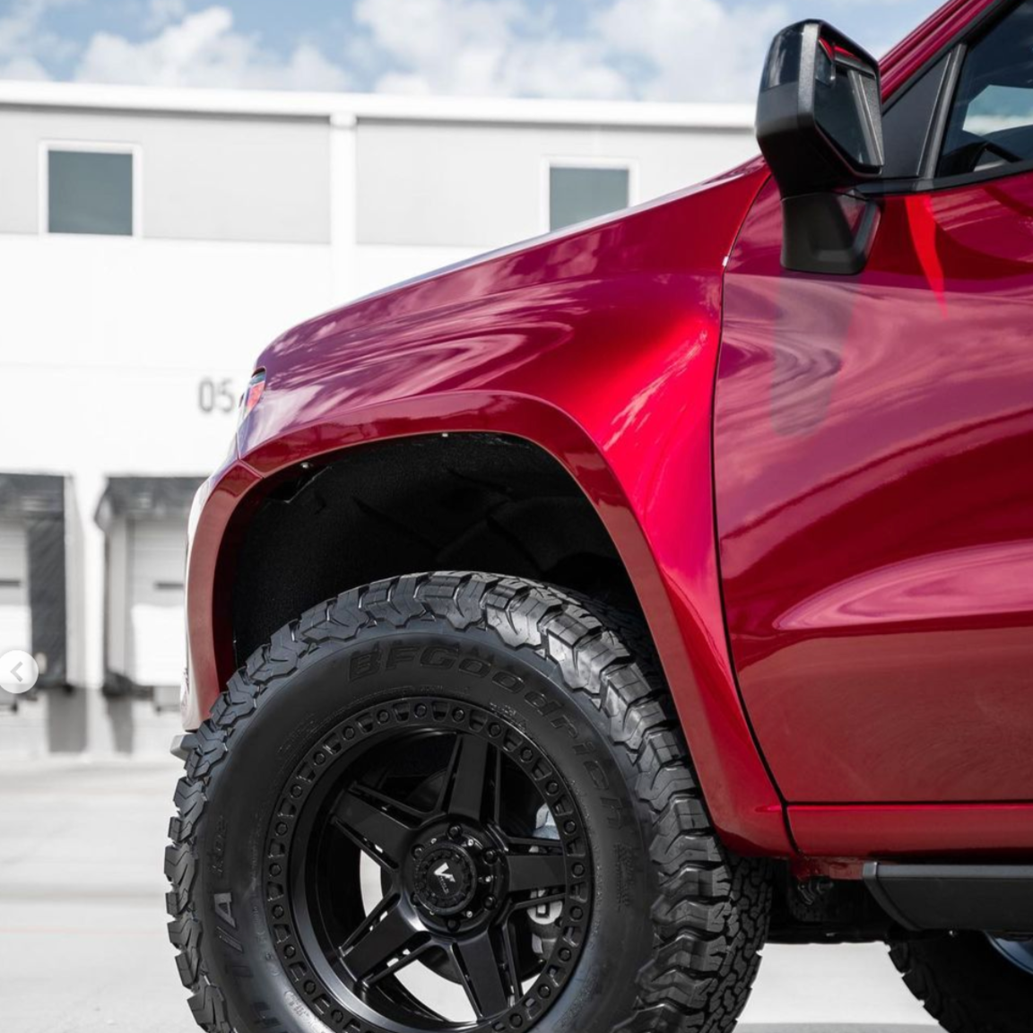 2019-2025 Chevrolet Silverado fender showcasing a red truck with off-road tires and a sleek design.