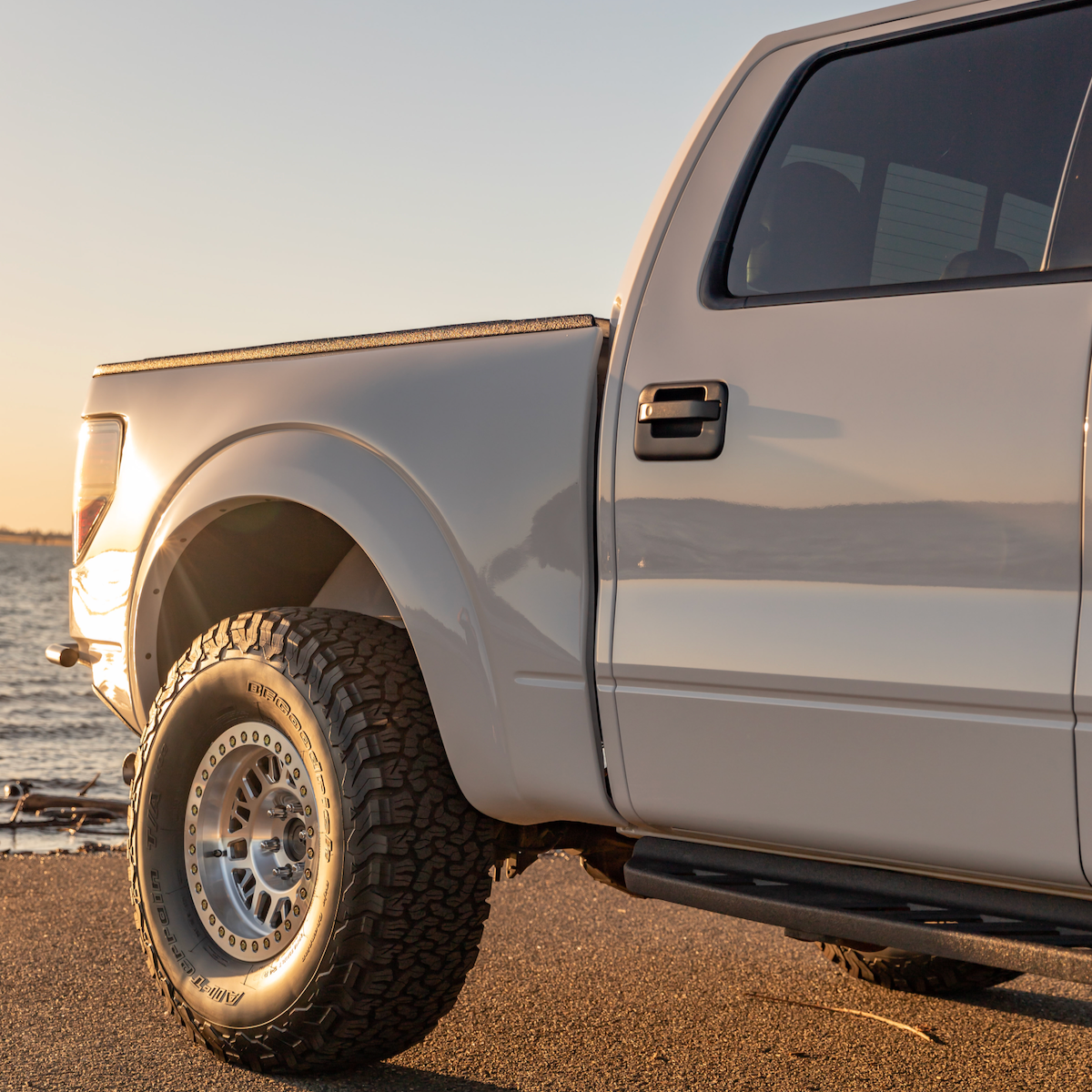 2010-2016 Ford Raptor bedsides showcasing a sleek design and rugged tire, ideal for offroad performance.