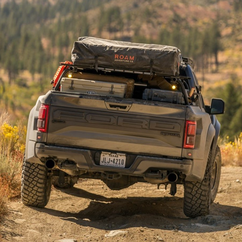 2017-2020 Ford Raptor with aftermarket bedsides, showcasing offroad gear and rugged terrain.