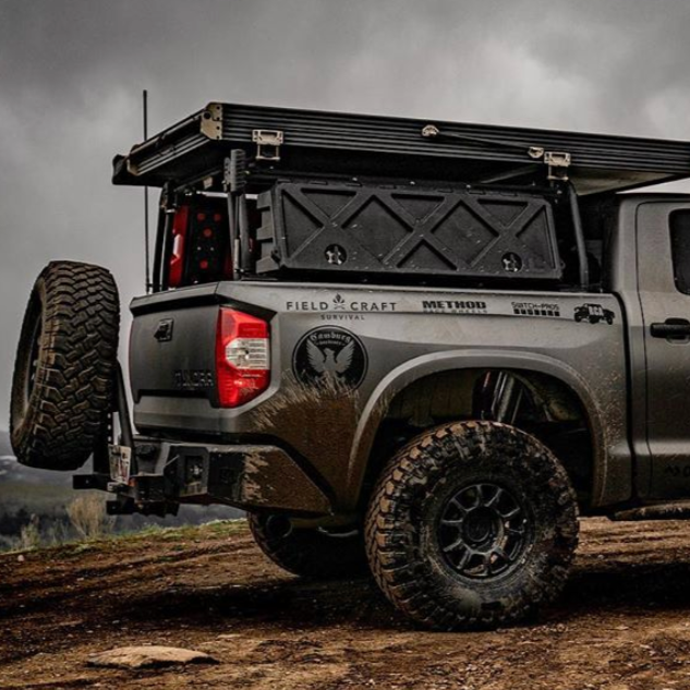 2014-2021 Toyota Tundra with custom bedsides, offroad tires, and a rooftop tent, showcasing rugged outdoor capability.