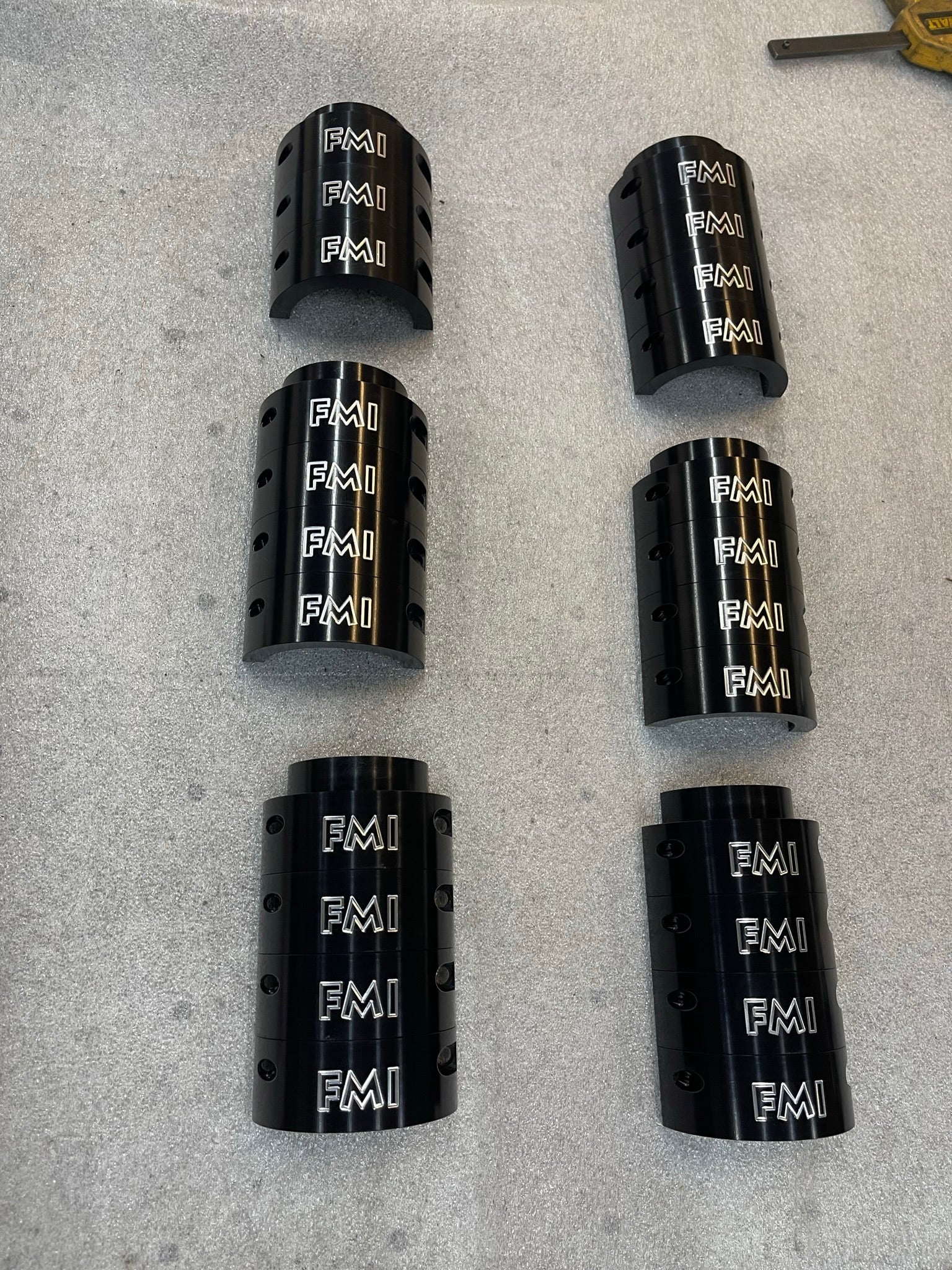 2025 Ram RHO 1.5 inch front leveling kit components featuring six black aluminum spacers with engraved FMI branding.