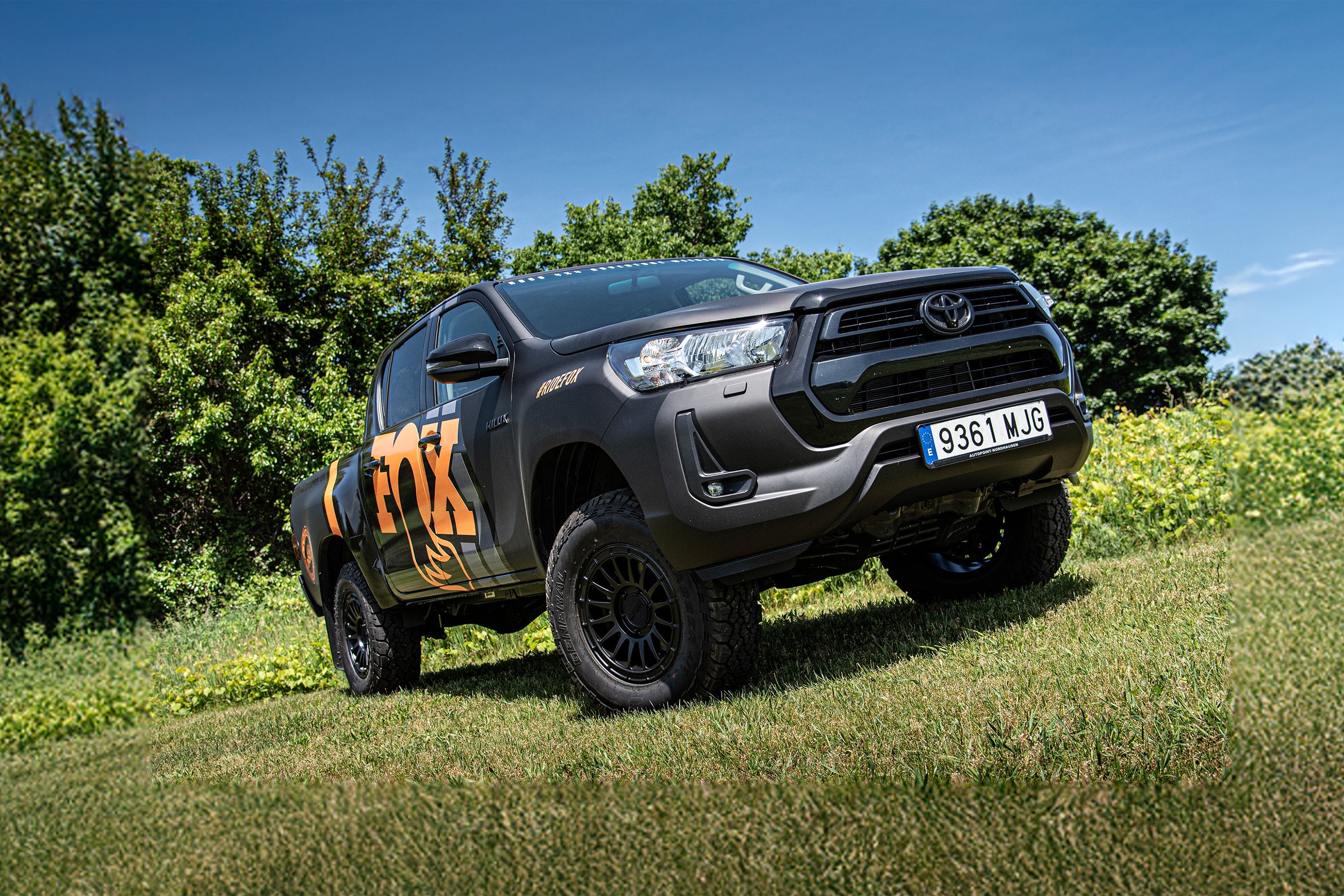 Toyota Hilux with a 2-inch lift kit and FOX coil-overs, showcasing enhanced off-road capability in a natural setting.