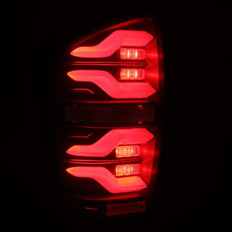 AlphaRex LUXX LED taillights for 2016-2021 Toyota Tacoma in black with sequential signal and active lighting features.