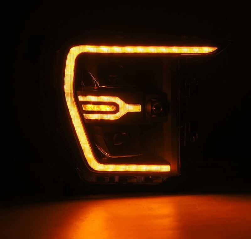 AlphaRex Luxx-Series projector headlights for 21-22 Ford F150 in black with activated sequential signal lighting.
