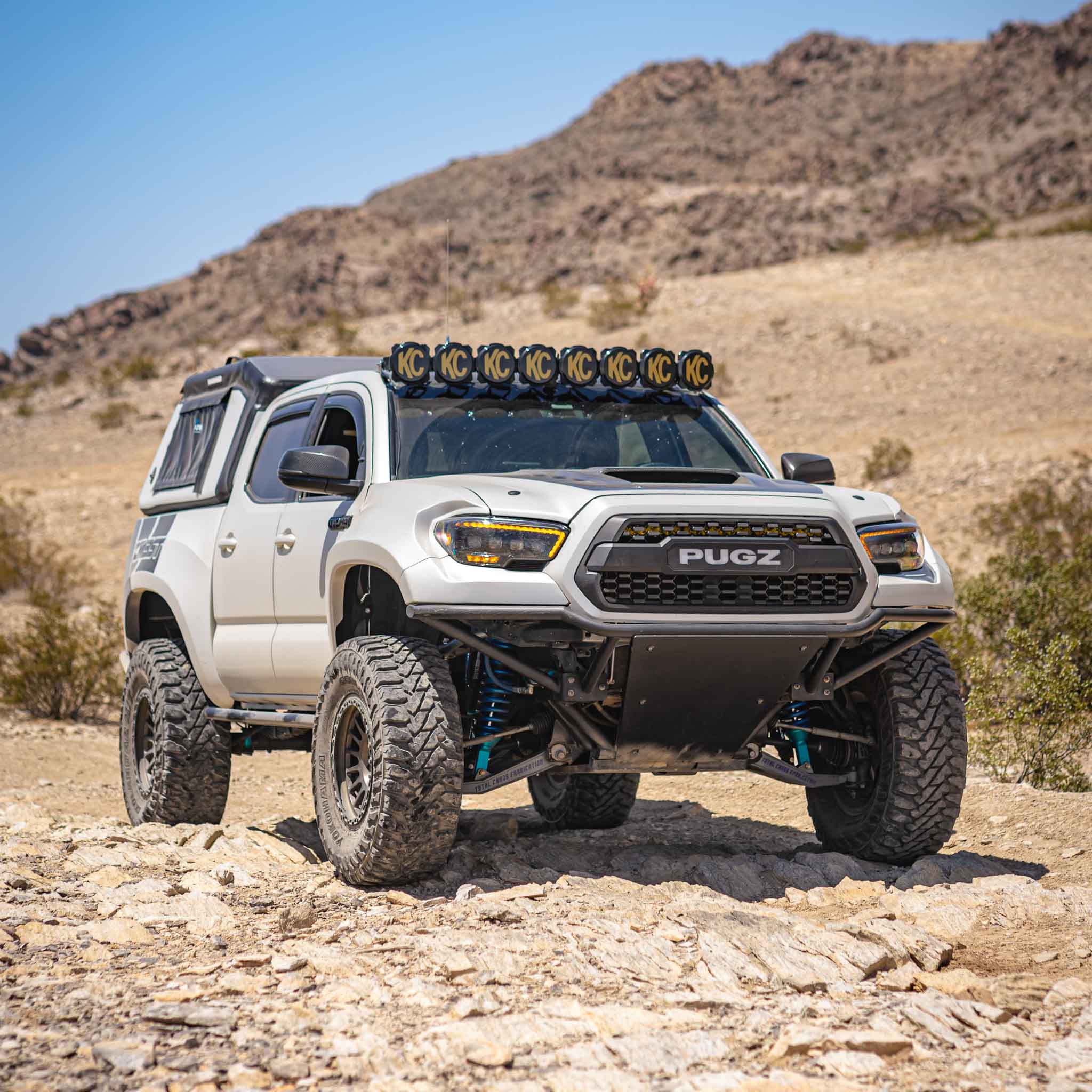 2016-2023 Toyota Tacoma with upgraded bedsides, showcasing rugged off-road capability in a desert landscape.