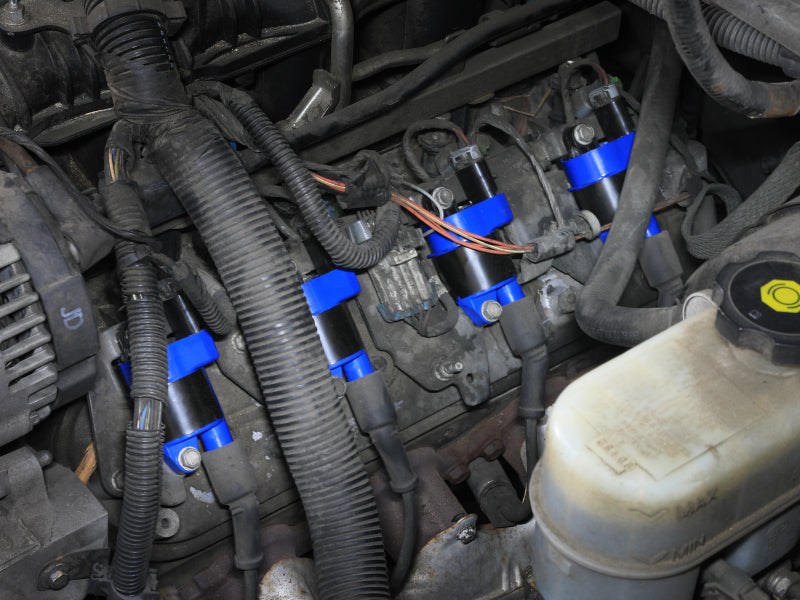 High-performance aFe SCORCHER ignition coils installed in a GM V8 engine compartment, enhancing power and efficiency.