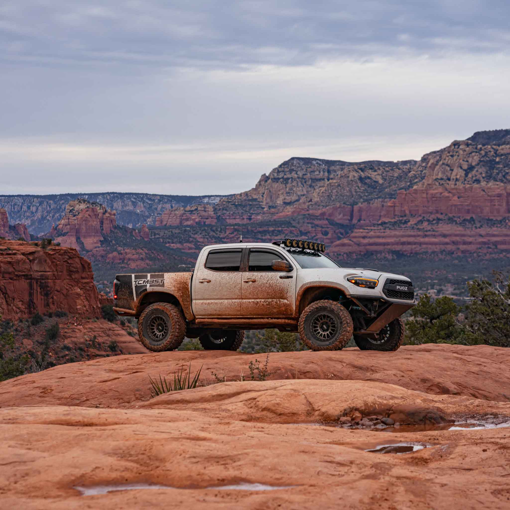 2016-2023 Toyota Tacoma with custom bedsides parked on rocky terrain, showcasing offroad capability and rugged design.