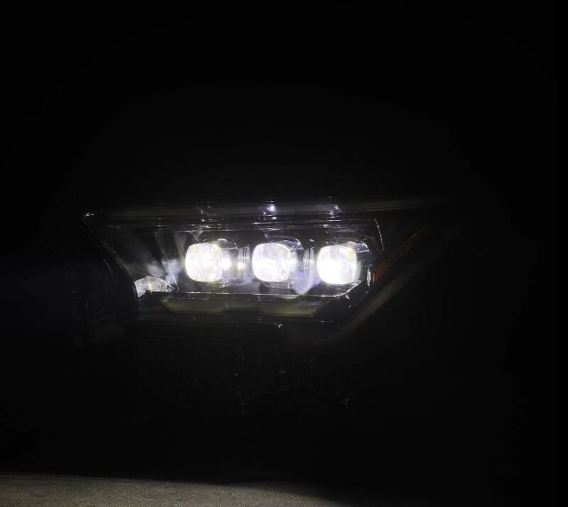 AlphaRex 2024 Toyota Tacoma NOVA-Series projector headlights in alpha-black with activation light, showcasing bright illumination.
