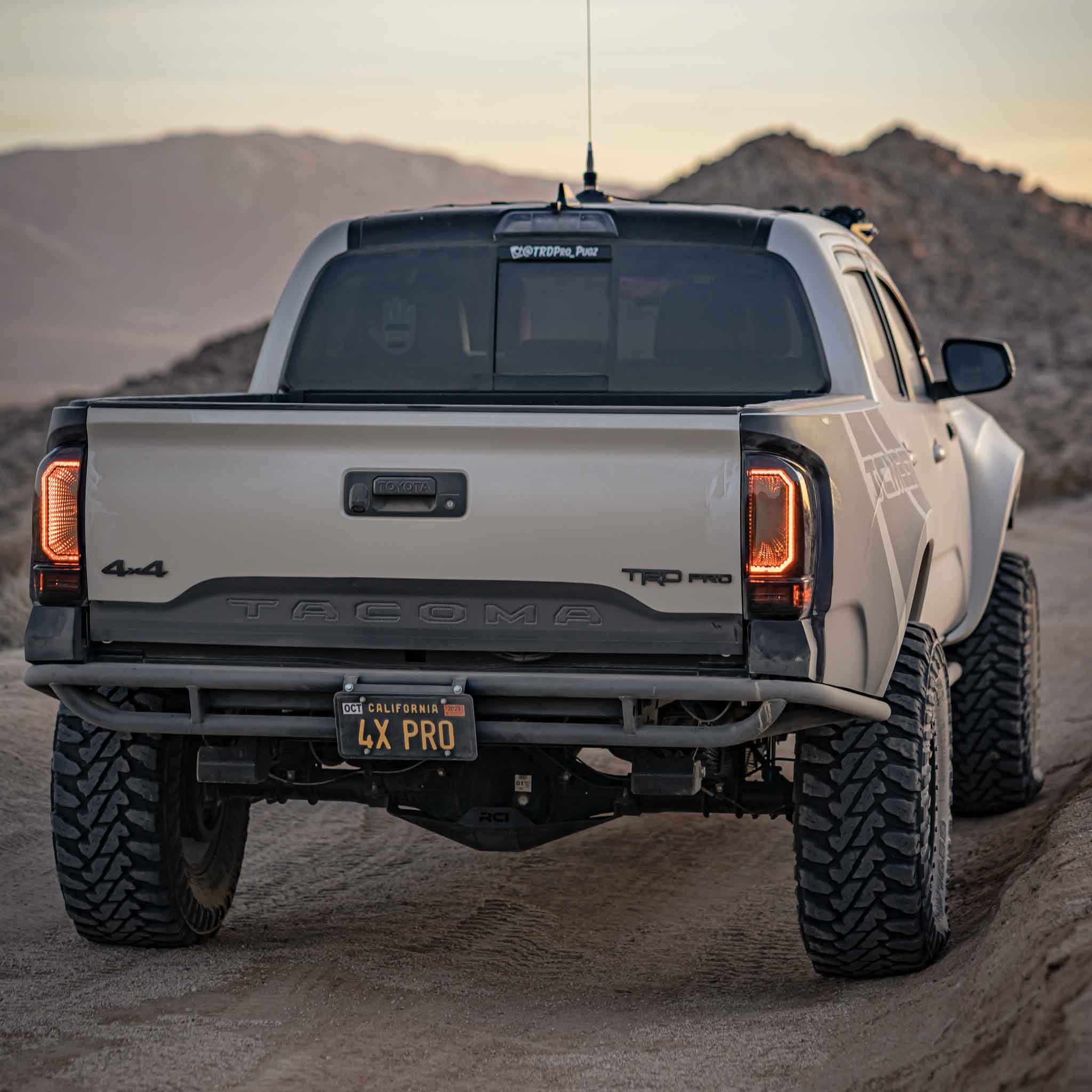 2016-2023 Toyota Tacoma with custom bedsides parked on a desert trail, showcasing offroad capabilities and rugged design.