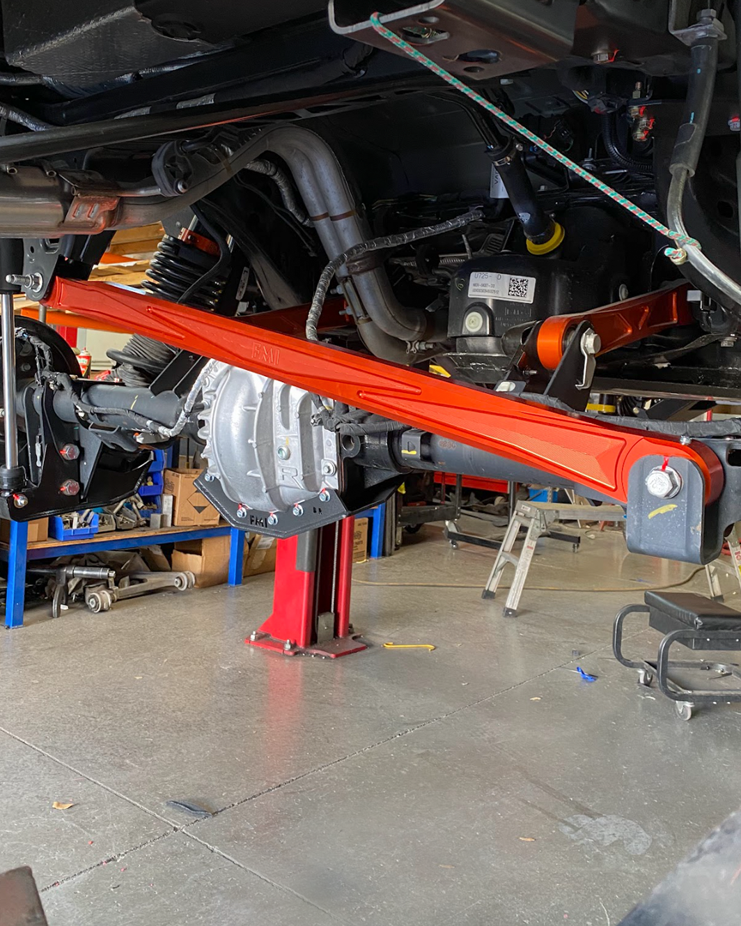 2022+ Bronco Raptor billet panhard bar with ultra-flex joint installed, showcasing offroad suspension components in a workshop.