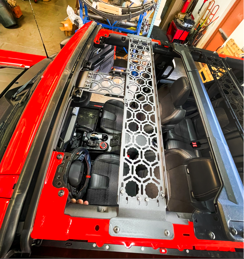 Inside view of a 2021 Bronco featuring an Adapt-A-Panel roof mount across the front seats, showcasing a short front panel design.