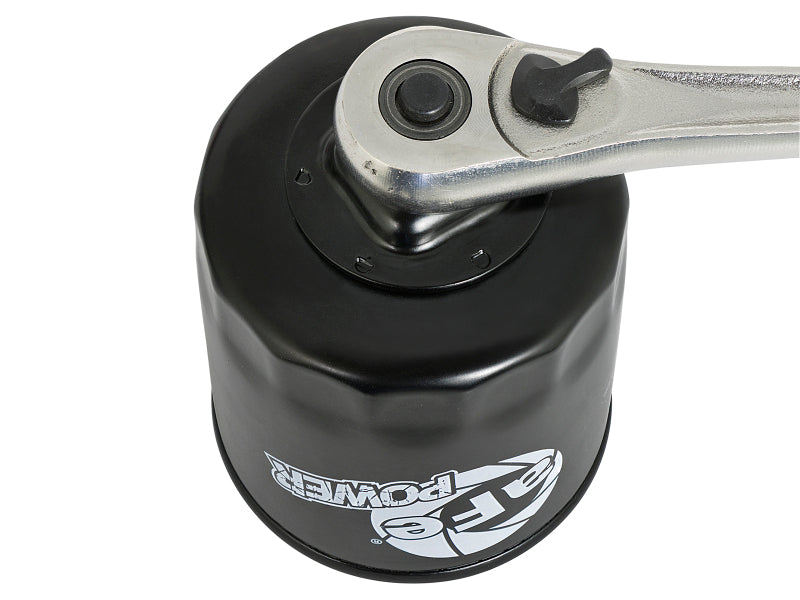 AFE PROGUARD oil filter with a wrench attached, showcasing its durable design for high-performance vehicles.