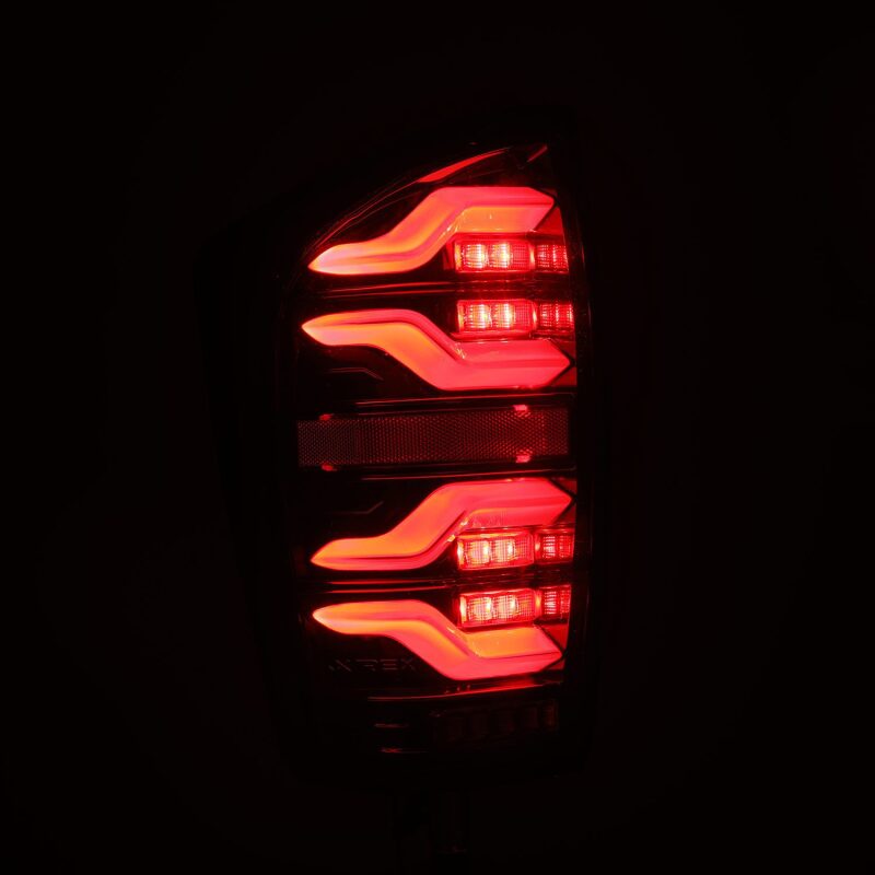AlphaRex LED taillights for 2016-2021 Toyota Tacoma in black with sequential signals and active lighting features.