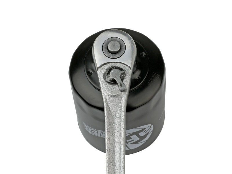 Afe PROGUARD oil filter with a ratchet tool attached, showcasing its durable design for optimal engine protection.