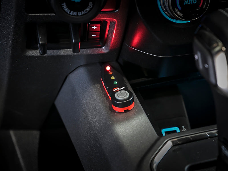 AFE SCORCHER Power Module installed in a Ford F-150, featuring LED indicators and a control button on the console.