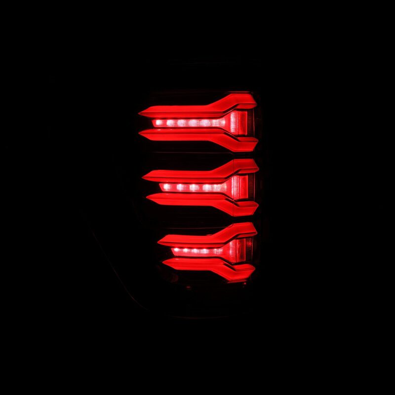 AlphaRex 21-22 Ford F150 LUXX LED projector tail lights in alpha-black with a sleek, modern design and bright red illumination.