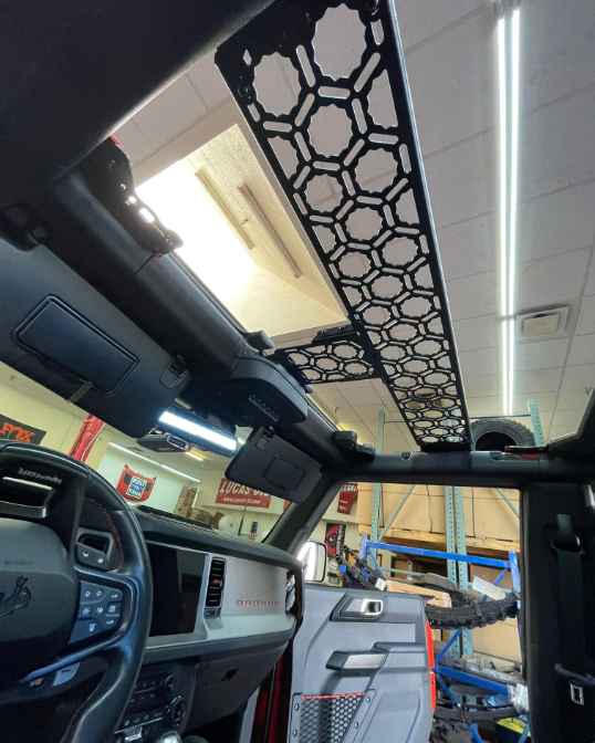 Inside view of a 2021 Bronco featuring an Adapt-A-Panel roof mount across the front seats, showcasing a sleek design.