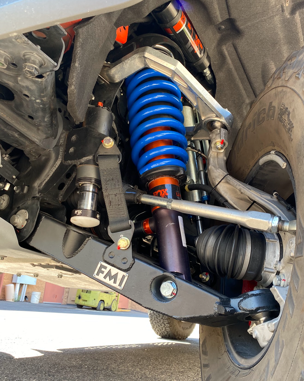 Mid travel front suspension kit for 2022+ Bronco Raptor, showcasing blue coil springs and robust components for off-road performance.