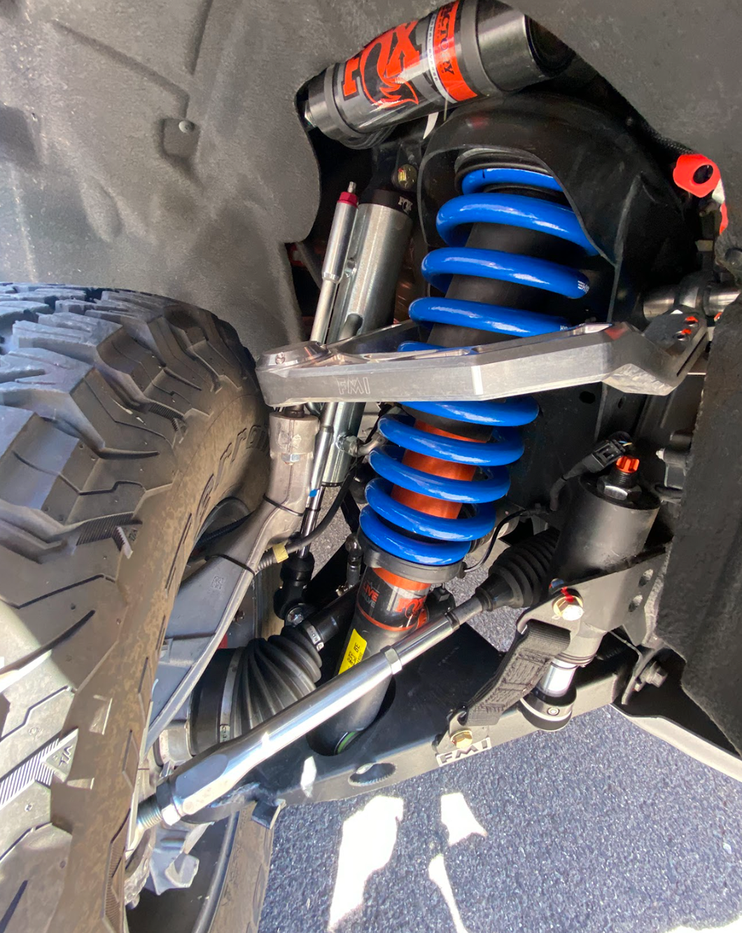 2022 Bronco Raptor mid travel front suspension kit showcasing blue coil springs and FOX shocks for enhanced off-road performance.