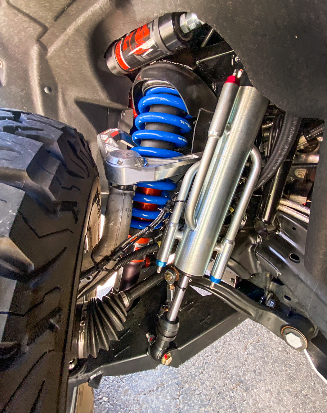 Mid travel front suspension kit for 2022+ Bronco Raptor showcasing blue coil springs and shock absorbers.
