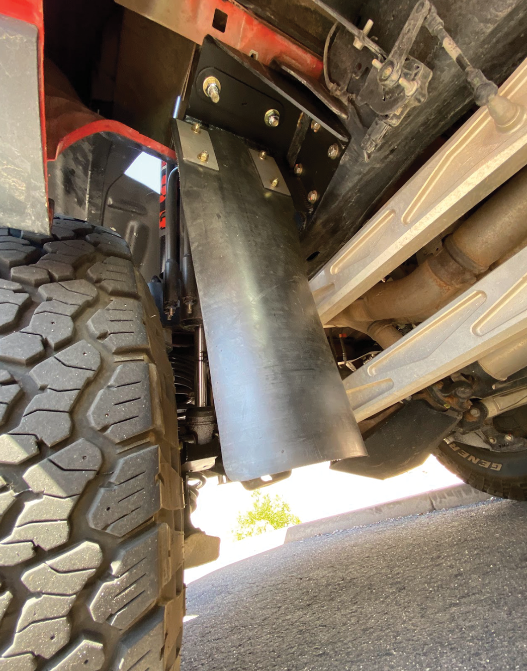 Rear shock guard mud flap frame mount kit for 2017-2024 Gen 2 and Gen 3 Raptor, showcasing installation under the vehicle.