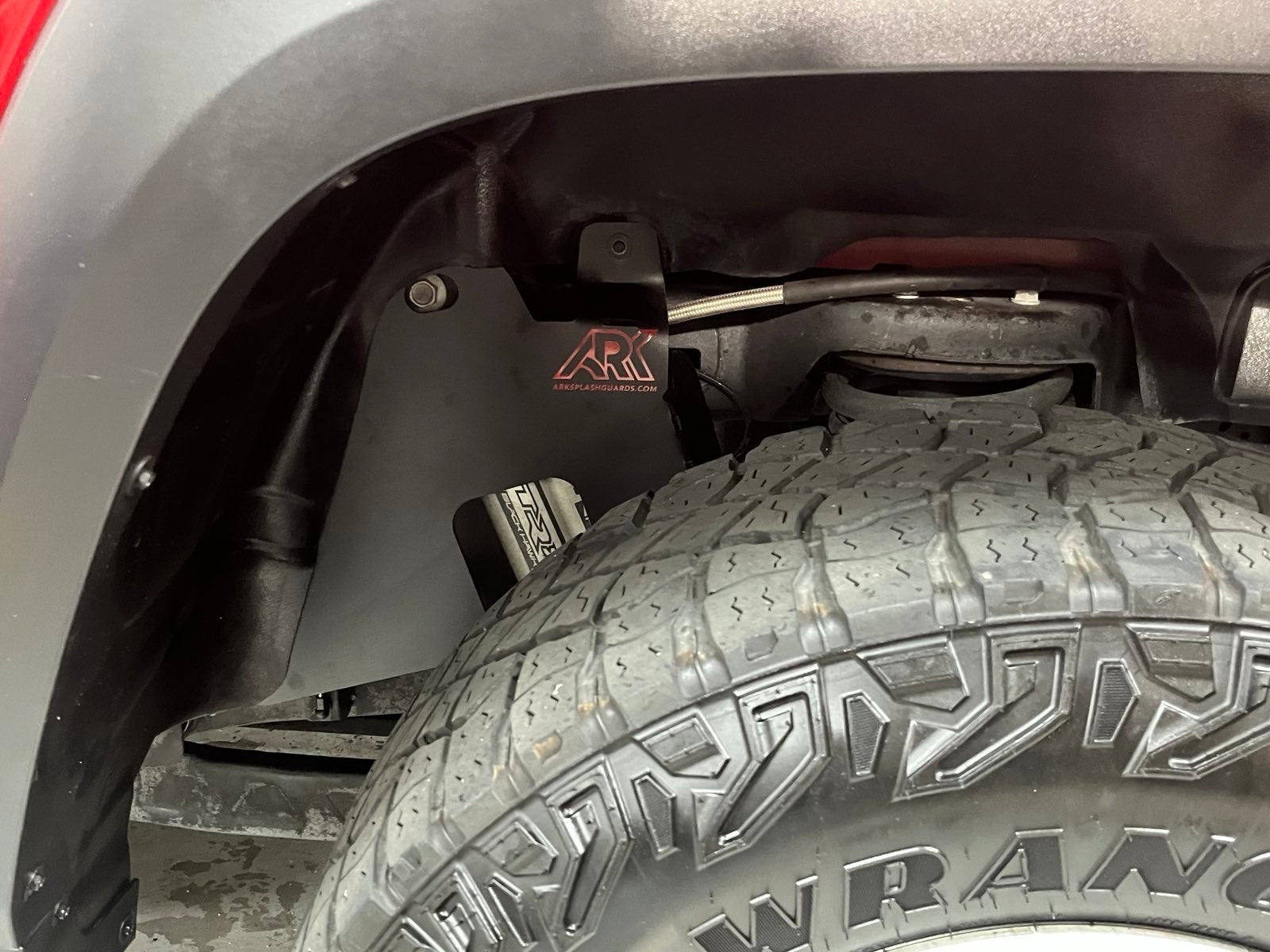 2025+ Dodge RAM RHO strut protection panel installed behind a tire, showcasing durable design for offroad protection.