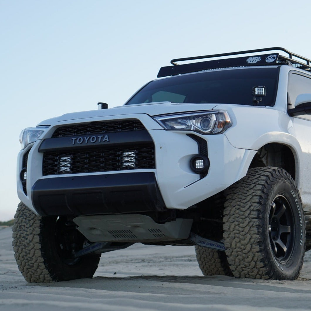 2010-2024 Toyota 4-Runner fenders showcased on a modified white SUV with offroad tires in a sandy environment.