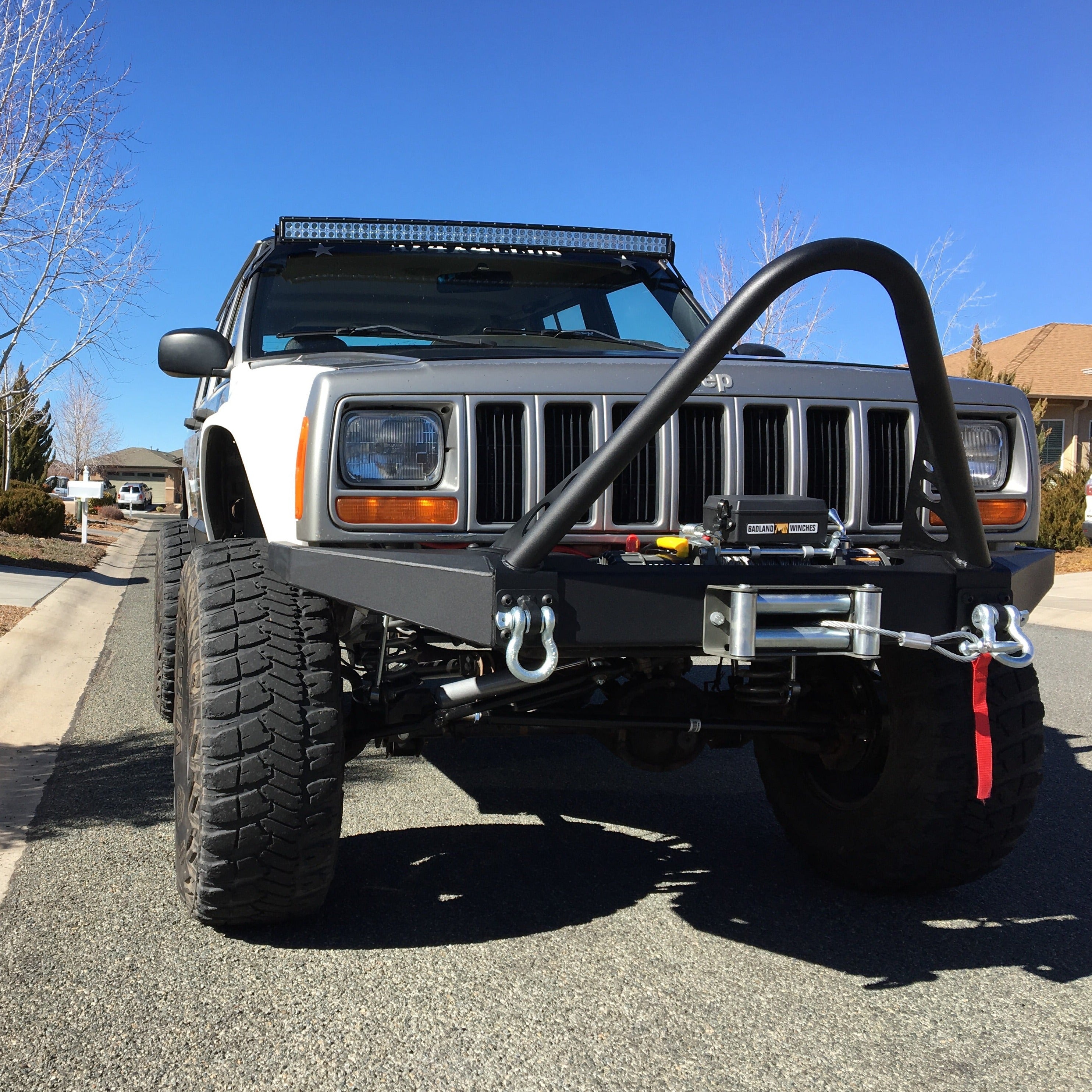 Front view of a modified 1984-2001 Jeep Cherokee showcasing aftermarket fenders and off-road accessories.