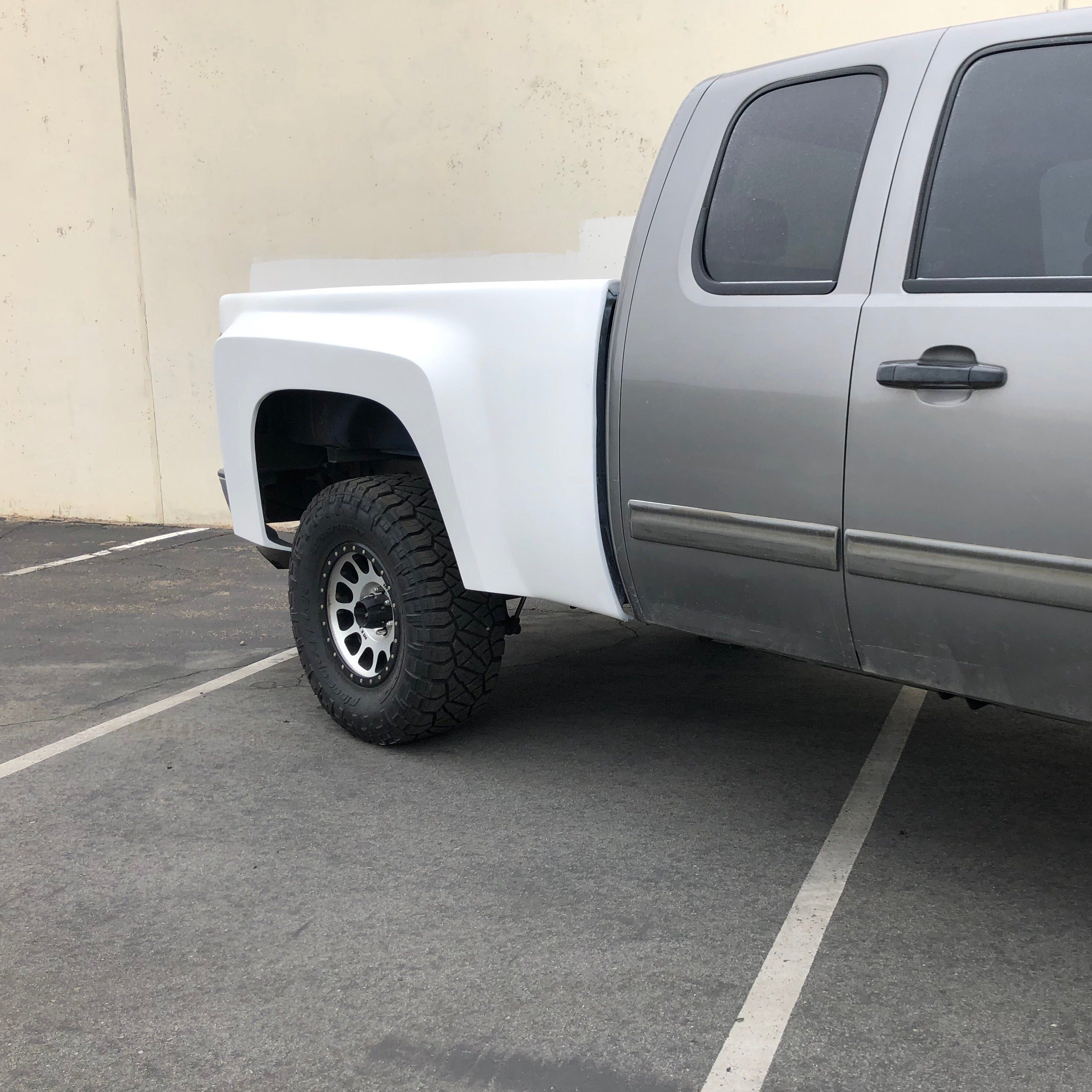 2007-2013 Chevrolet Silverado bedsides installed on a silver truck, showcasing offroad tires and a rugged design.