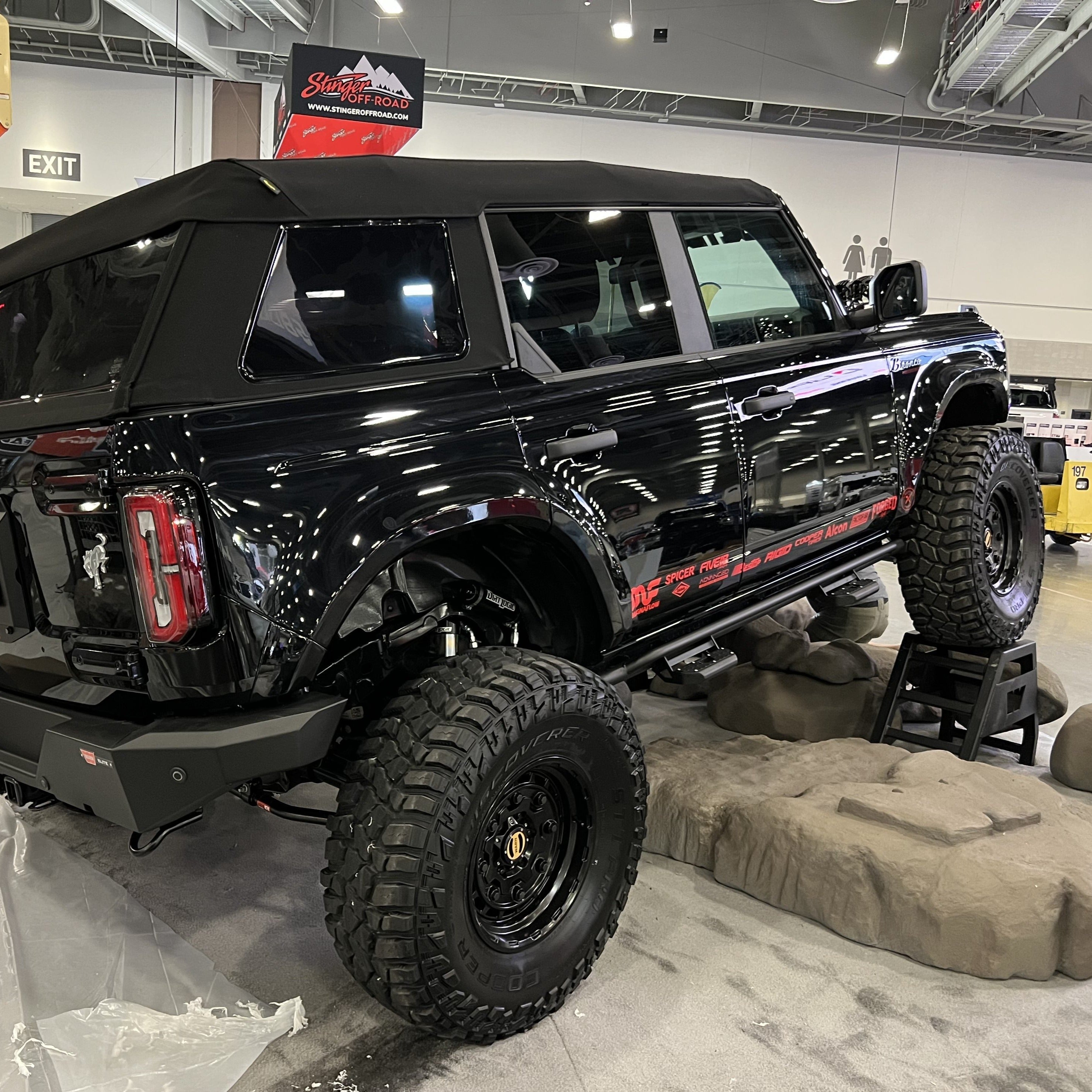 2021-2025 Ford Bronco 4-Door Rear Quarter Kit displayed on a lifted black Bronco with offroad tires in a showroom.