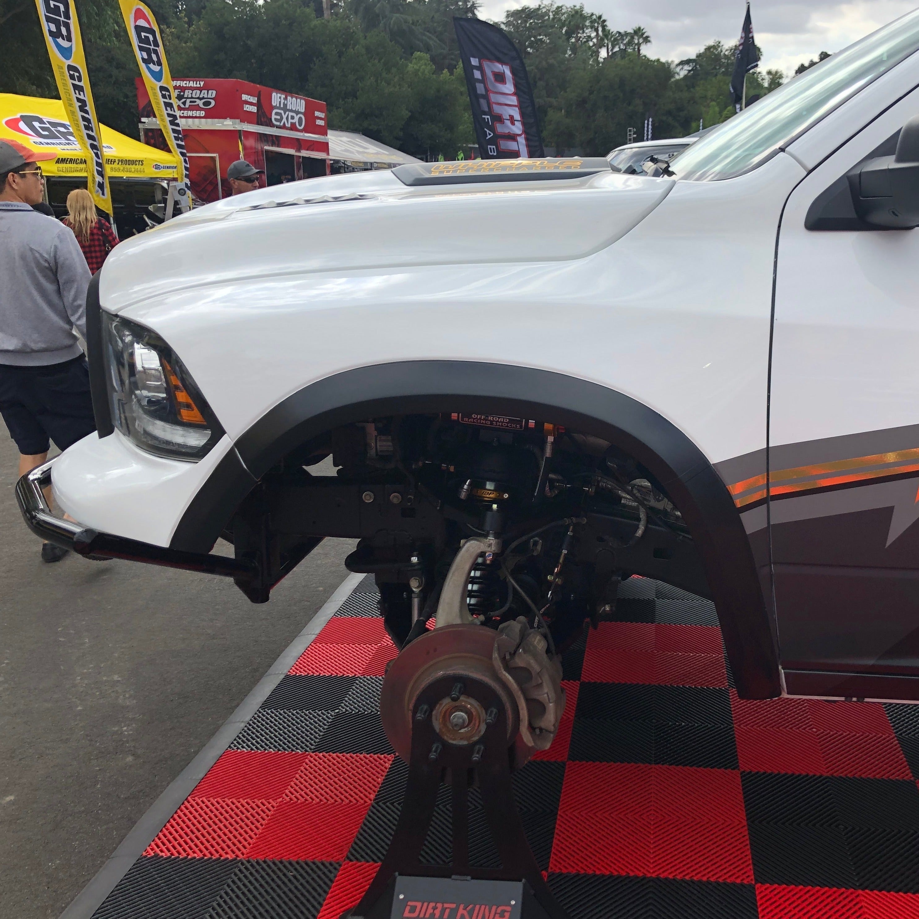 2009-2018 Dodge Ram TRX Kit displayed on a vehicle, showcasing suspension and wheel components at an outdoor event.