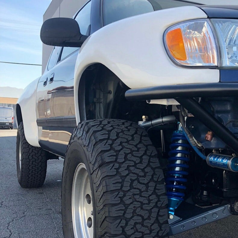 2000-2006 Toyota Tundra fenders showcasing a lifted truck with off-road tires and suspension components.