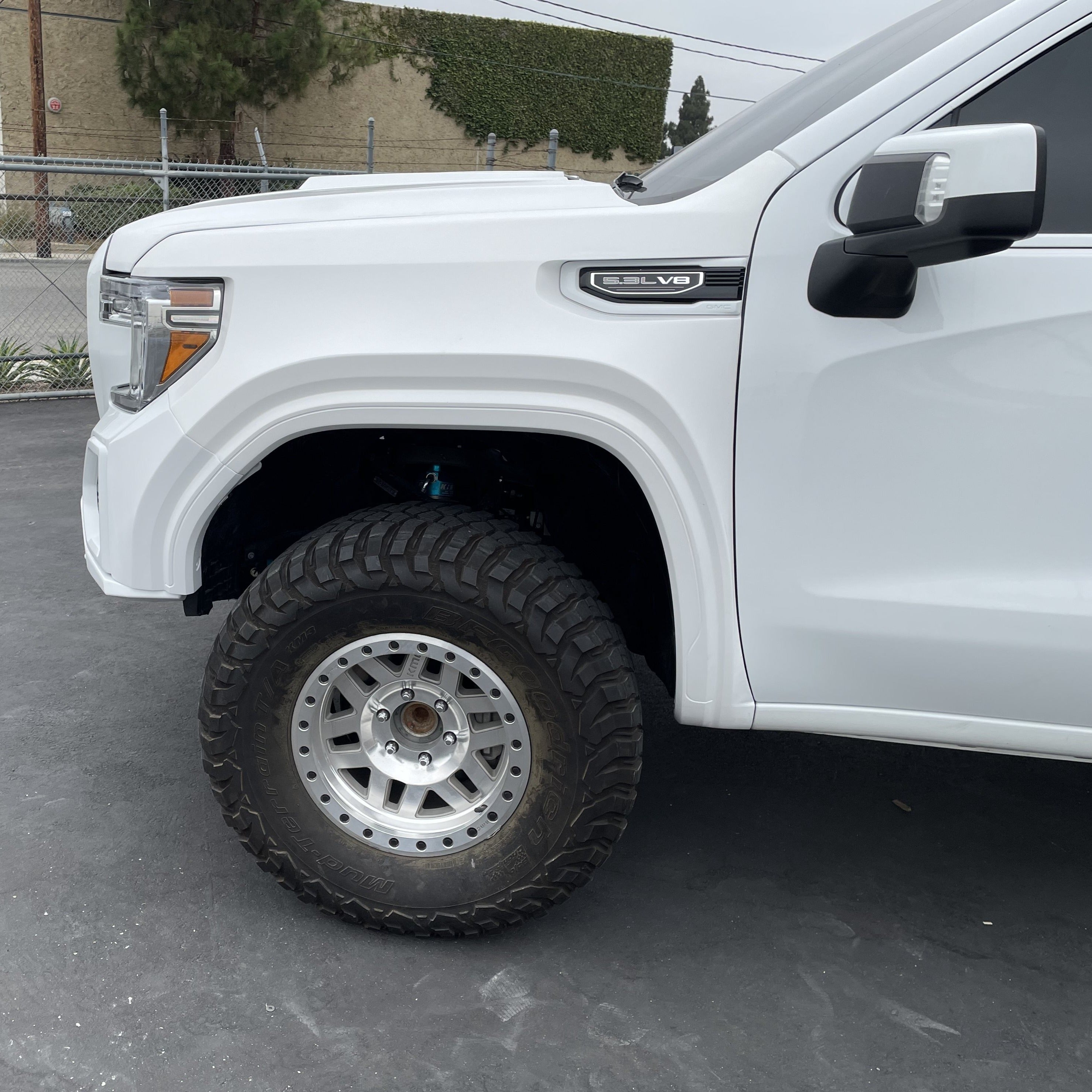 2019-2025 GMC Sierra fender showcasing a lifted truck with off-road tires and a clean white finish.