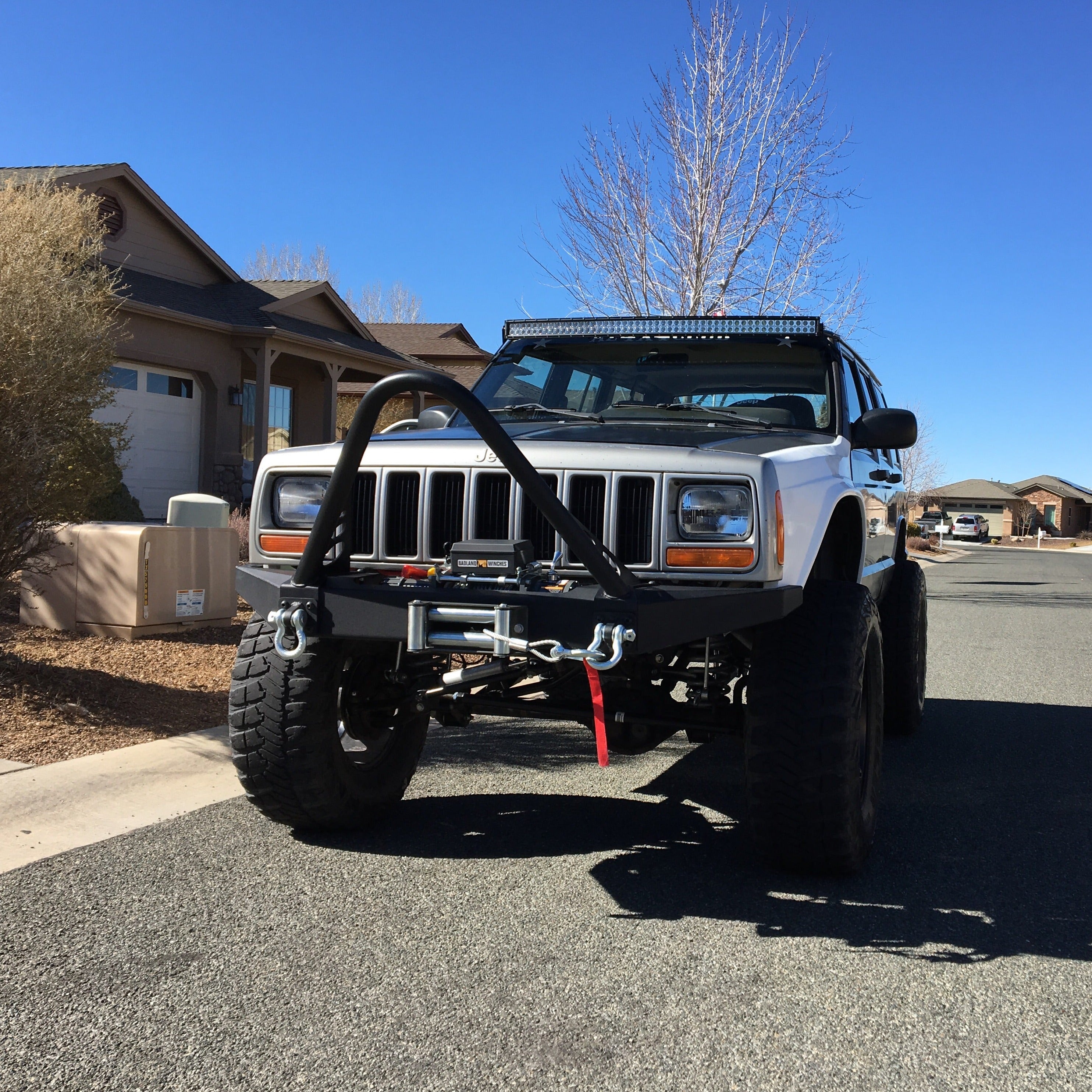 1986-1992 Jeep Comanche fenders installed on a lifted Jeep with offroad accessories parked on a residential street.