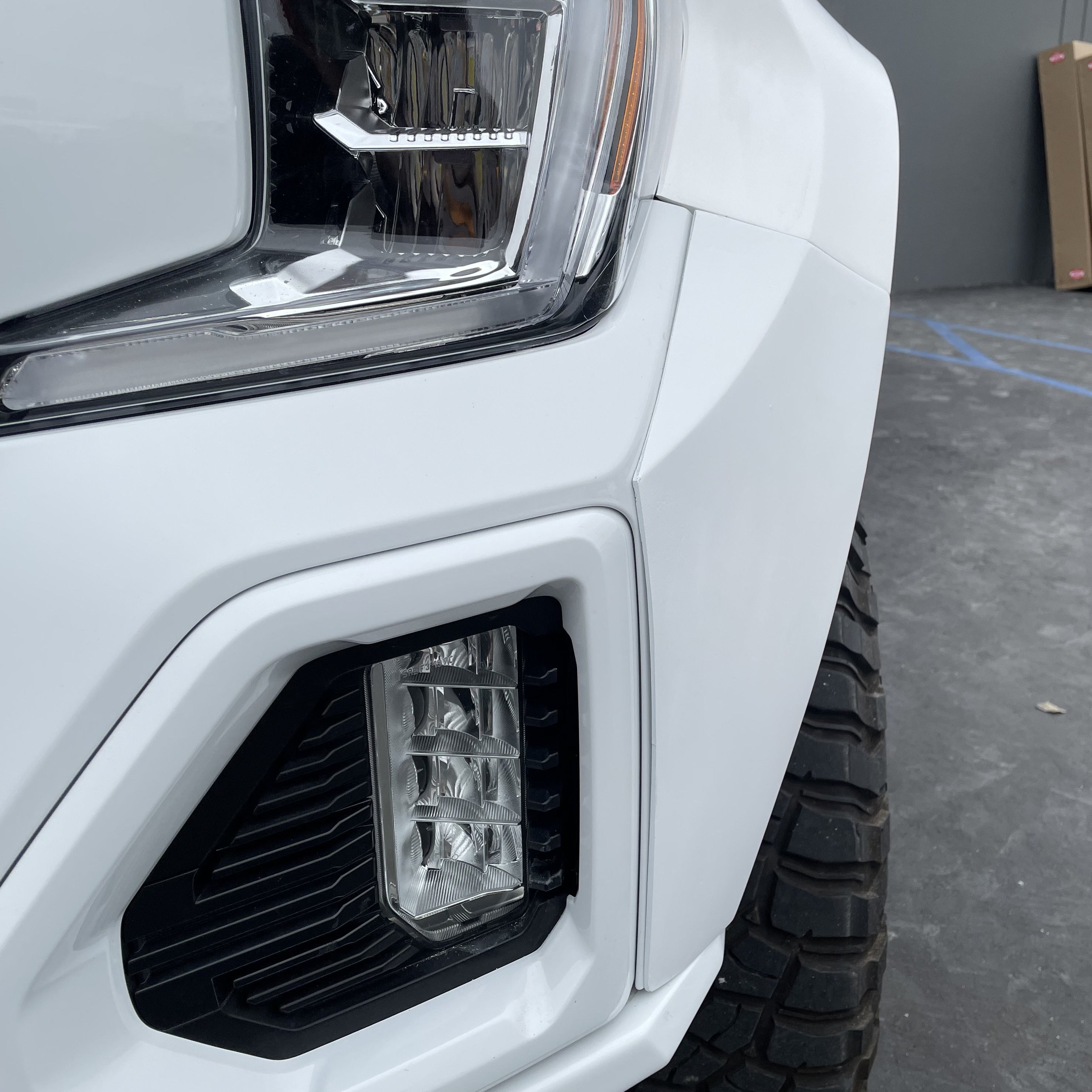 Close-up of a 2019-2025 GMC Sierra fender showcasing its sleek design and integrated lighting features.