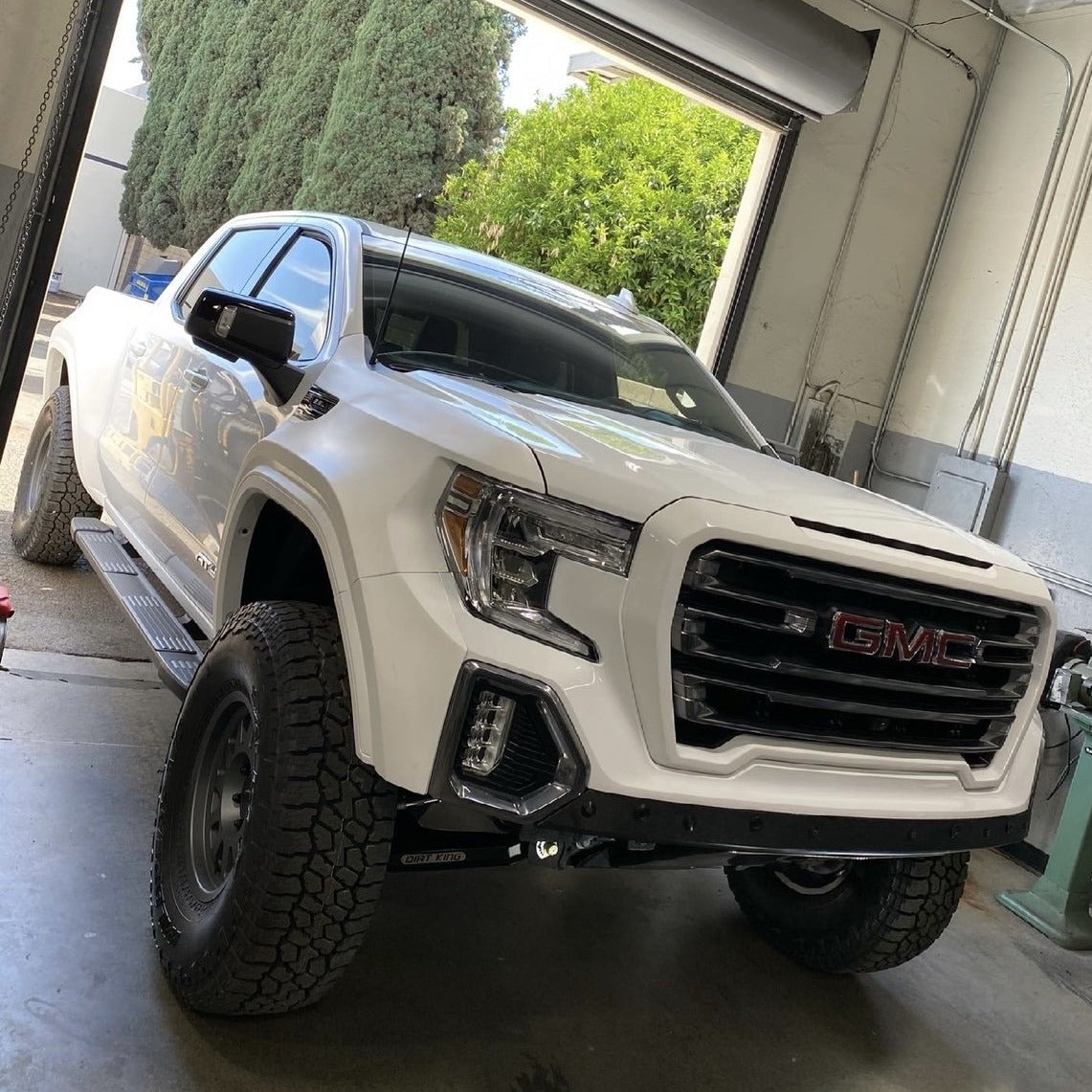 GMC Sierra truck with custom modifications, showcasing enhanced offroad capabilities and rugged design.