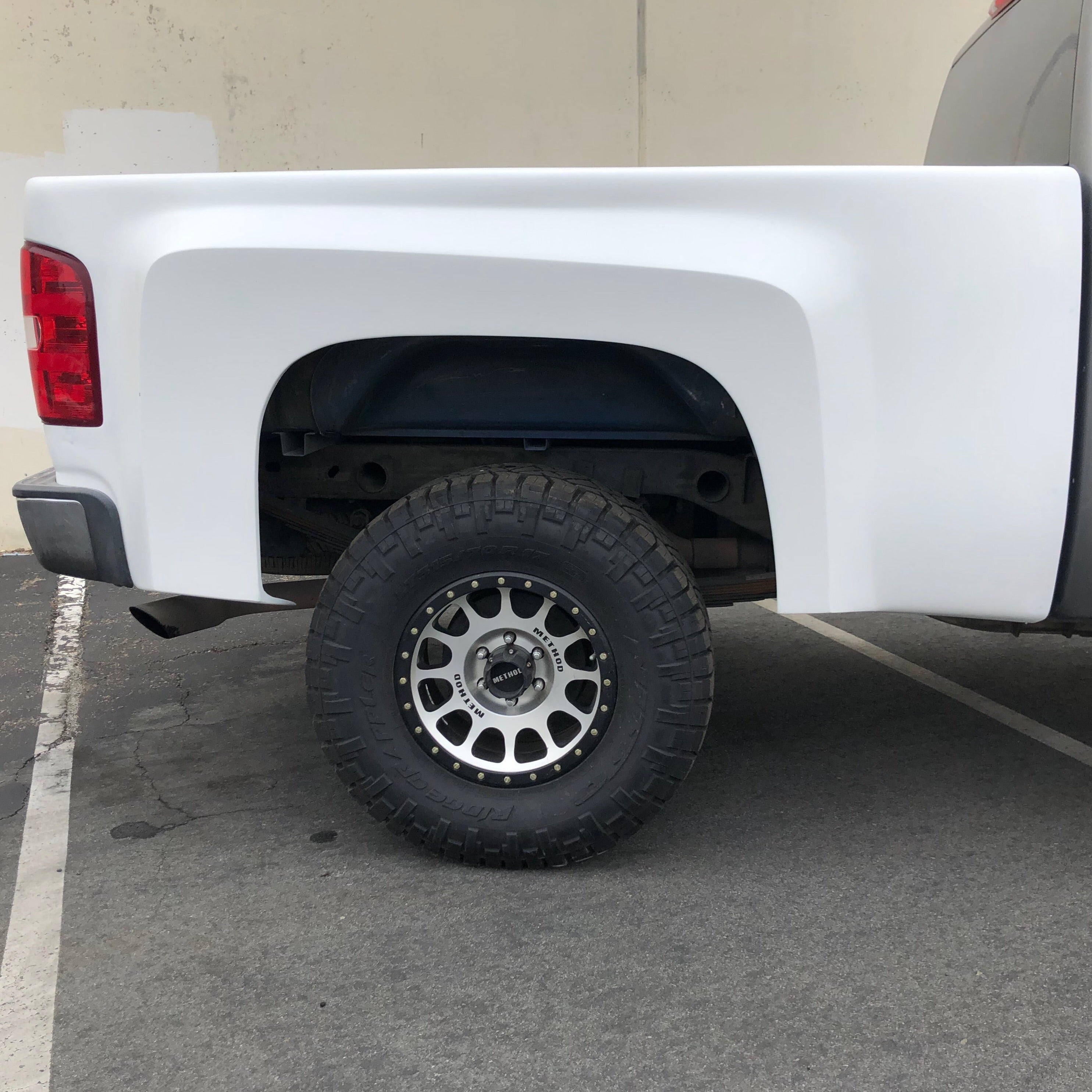 2007-2013 Chevrolet Silverado bedsides showcasing a white finish and rugged tire for offroad performance.