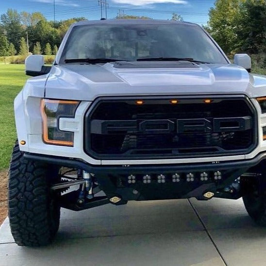 Front view of a 2017-2020 Ford Raptor showcasing custom fenders and aggressive offroad tires, parked outdoors.