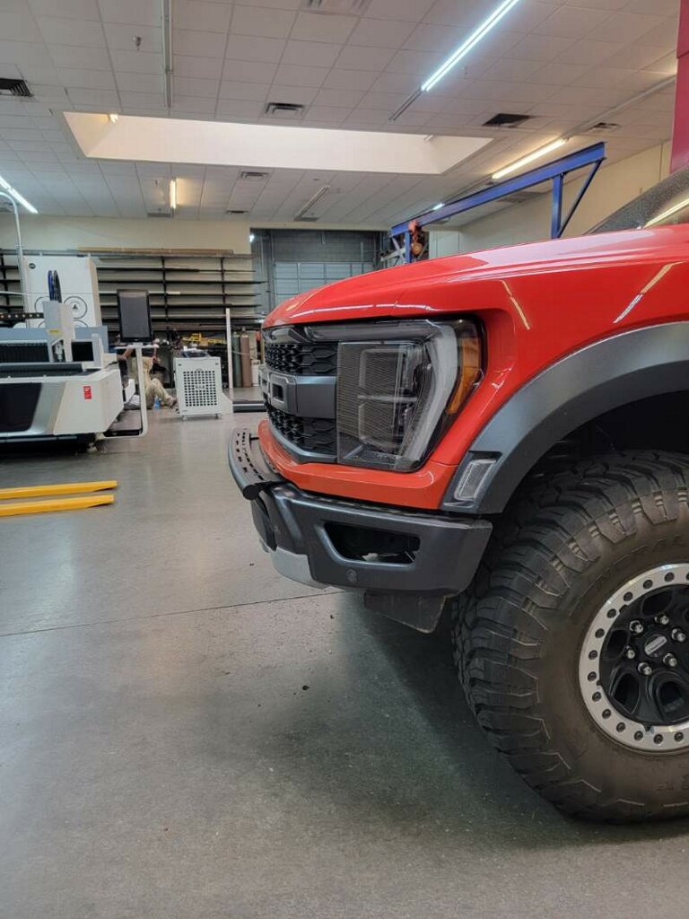 2024 Raptor Front Light Mount Kit displayed on a red truck, showcasing a modular bumper for versatile light installation.