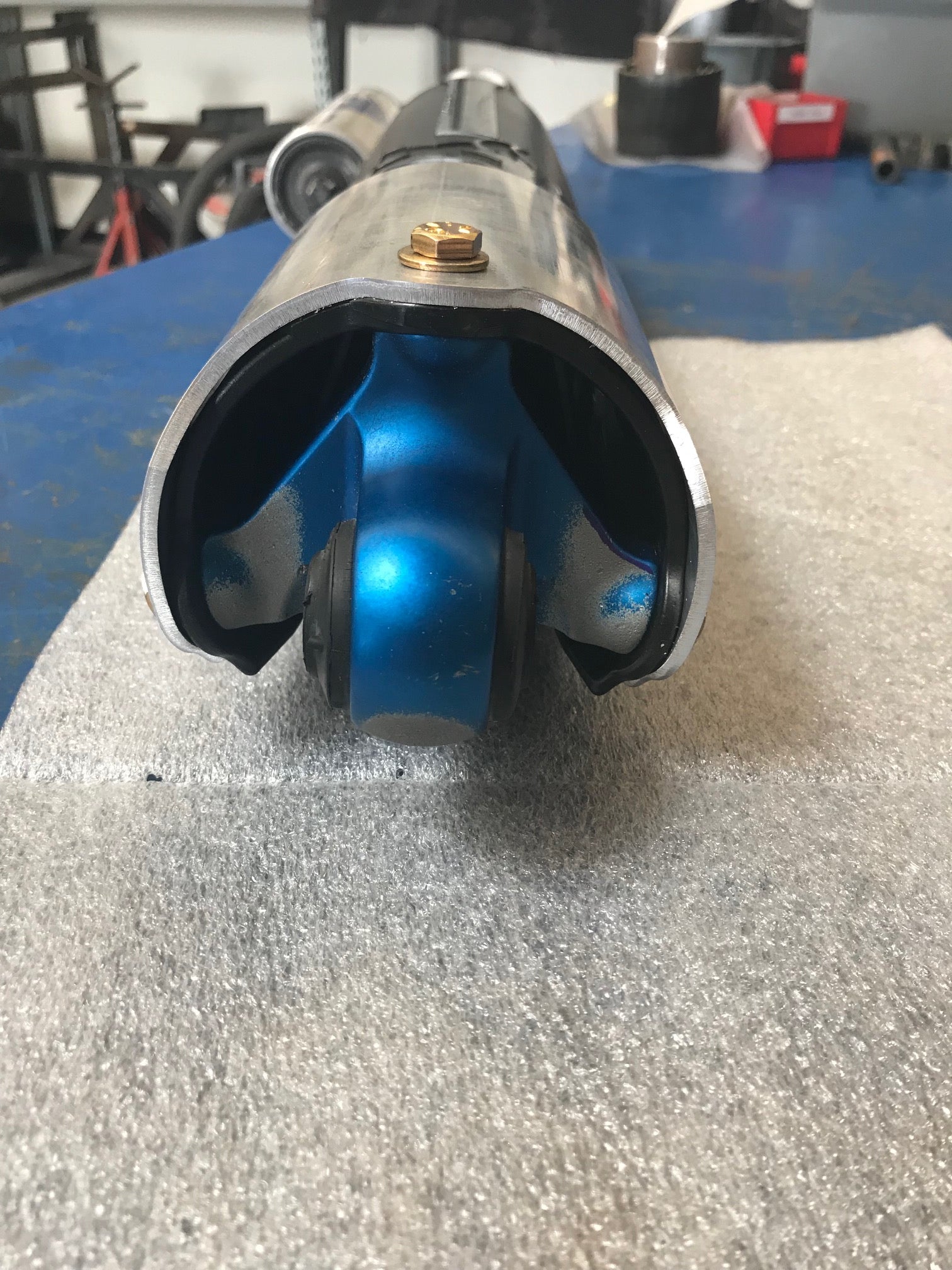 Rear shock guard for 2017-2024 Ford Raptor, showcasing a blue protective cover and metallic finish for durability.