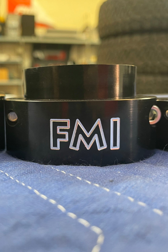 2025 Ram RHO 2 inch front leveling kit component showcasing the FMI logo on a black leveling spacer.