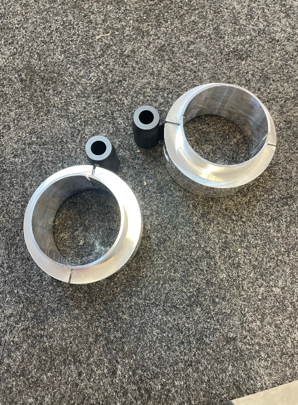 2025 Ram RHO 2 inch front leveling kit components including aluminum spacers and rubber bushings on a gray surface.