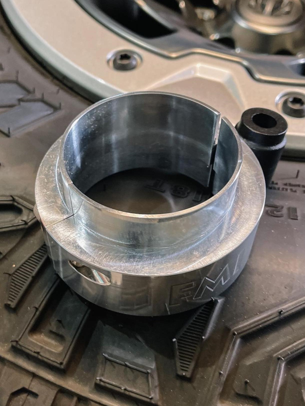 Aluminum spacer from the 2025 Ram RHO 2.5 inch front leveling kit, placed on a rugged tire tread.